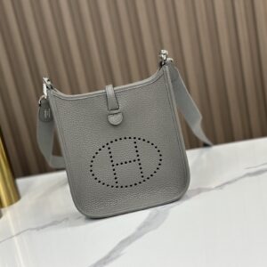 Replica Hermès Gris Meyer Clemence Mini Evelyne 16 TPM Bag – High-quality replica Hermès bag in Gris Meyer Clemence leather with perforated "H" and gold-tone hardware.