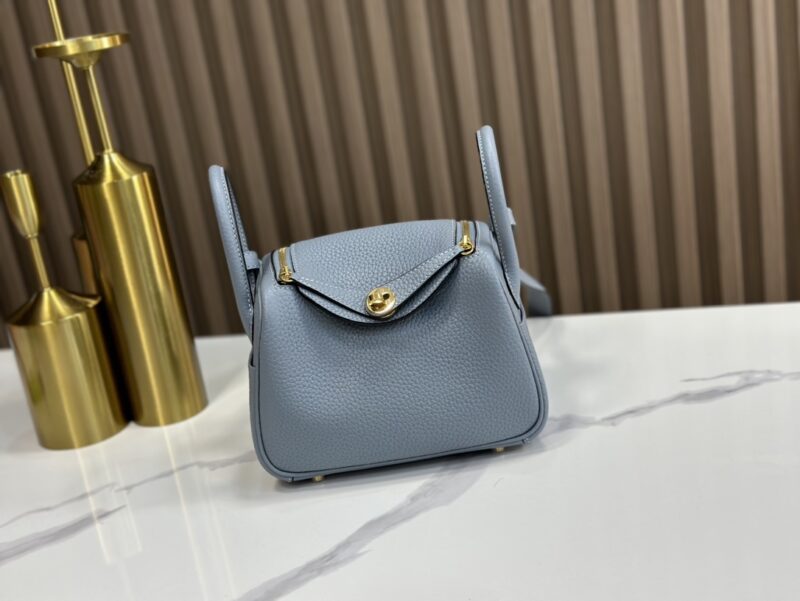 Replica Hermès Mini Lindy Shoulder Bag in Bleu Lin Clemence Leather – High-quality replica Hermès bag with soft blue leather and gold-tone hardware.